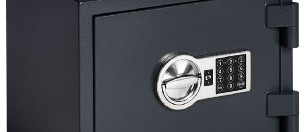 Image of a closed dark grey safe and big hinges. There is a black keypad with white numbers all on top of a silver